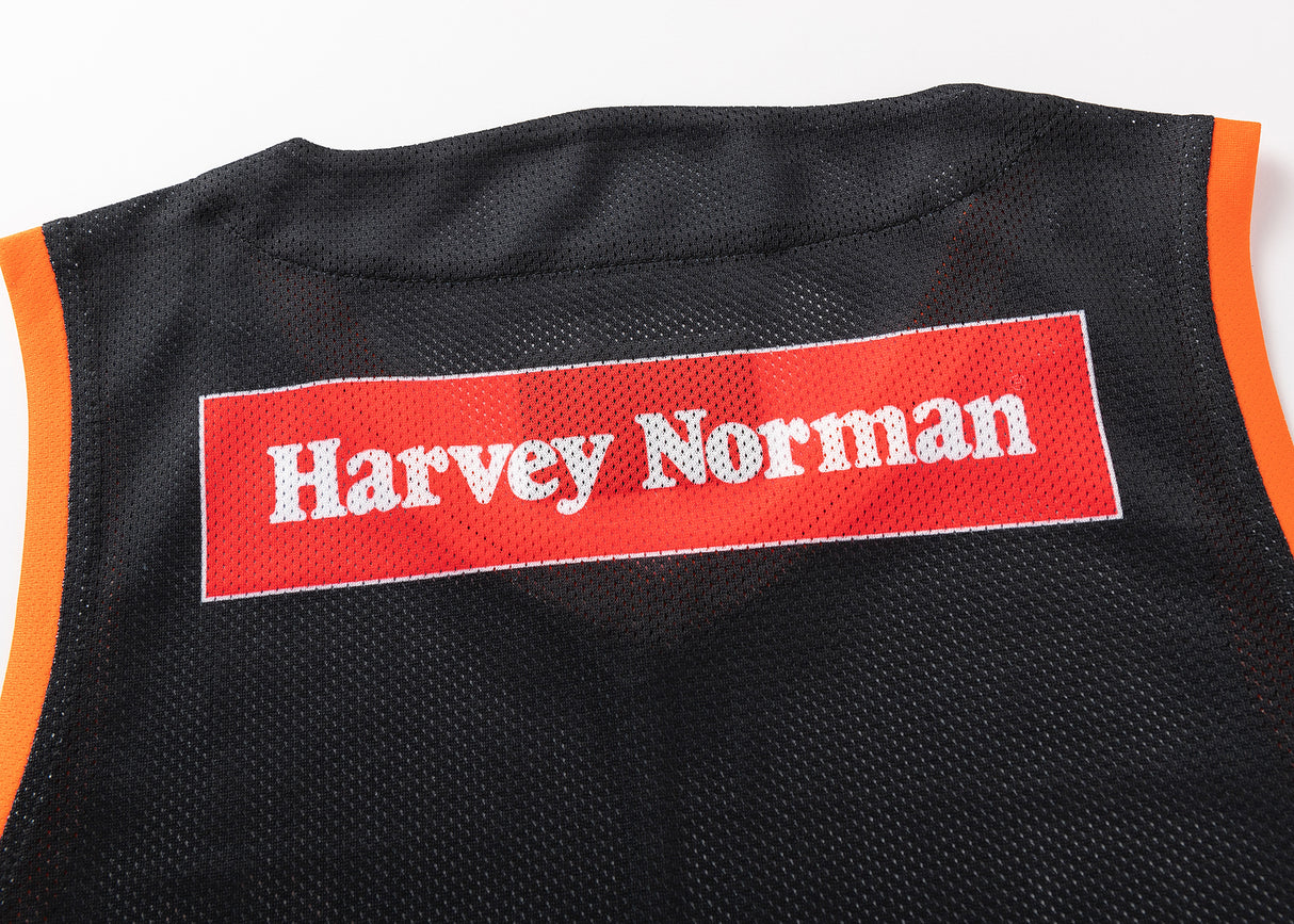The NRL Indigenous All Stars 25/26 Pro Training Singlet by Classic Sportswear is a black mesh jersey with orange trim, featuring a "Harvey Norman" logo on a red and white patch, combining style and performance for fans.