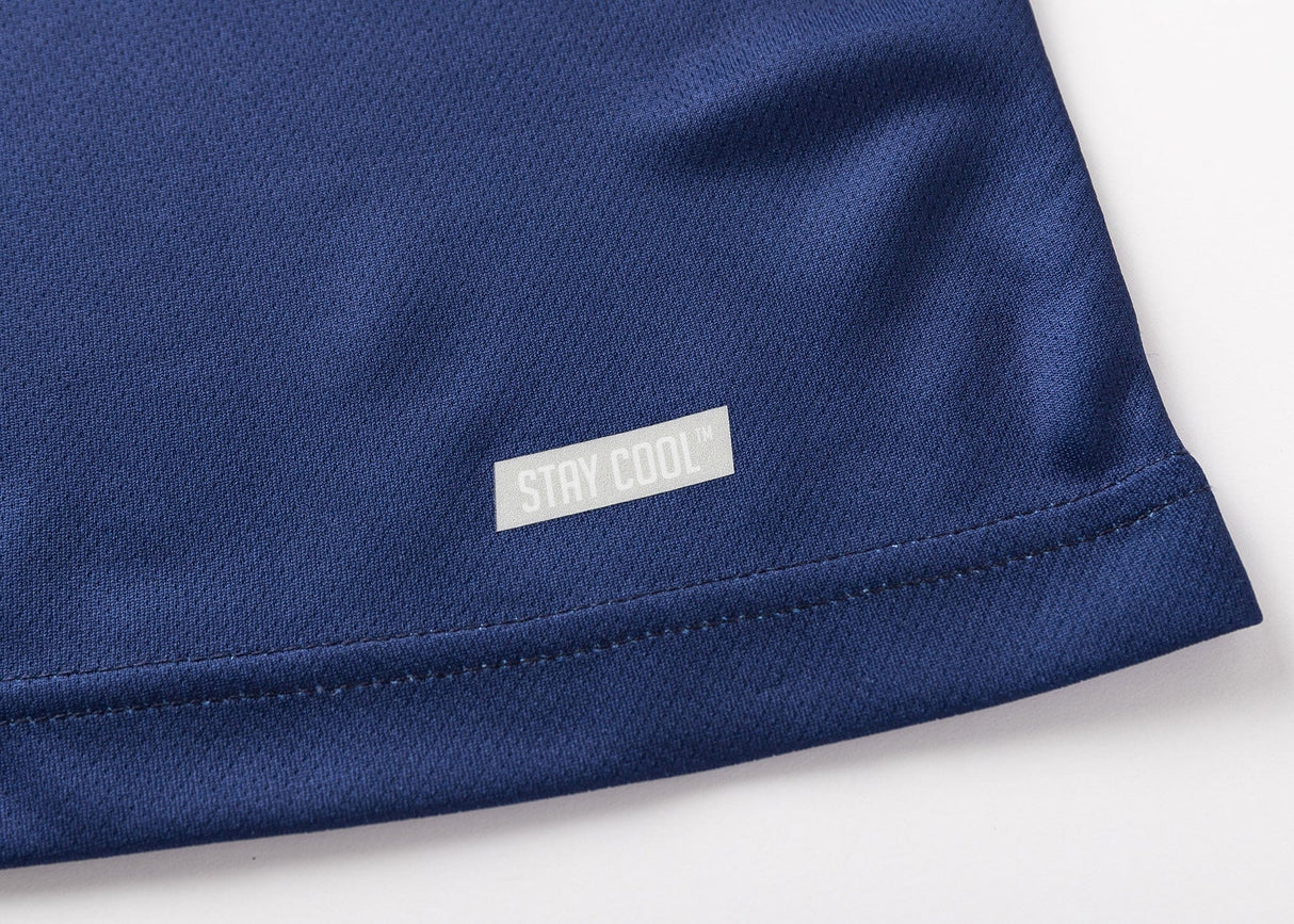 Close-up of the bottom corner of a dark blue fabric featuring a small "STAY COOL" label, echoing the timeless appeal of the Blues Super Rugby 25/26 Team Polo by Classic Sportswear.