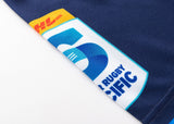 Close-up of the Blues Super Rugby 25/26 Team Polo by Classic Sportswear, showing part of the team logo with "5" and "Rugby Pacific" on navy blue fabric.