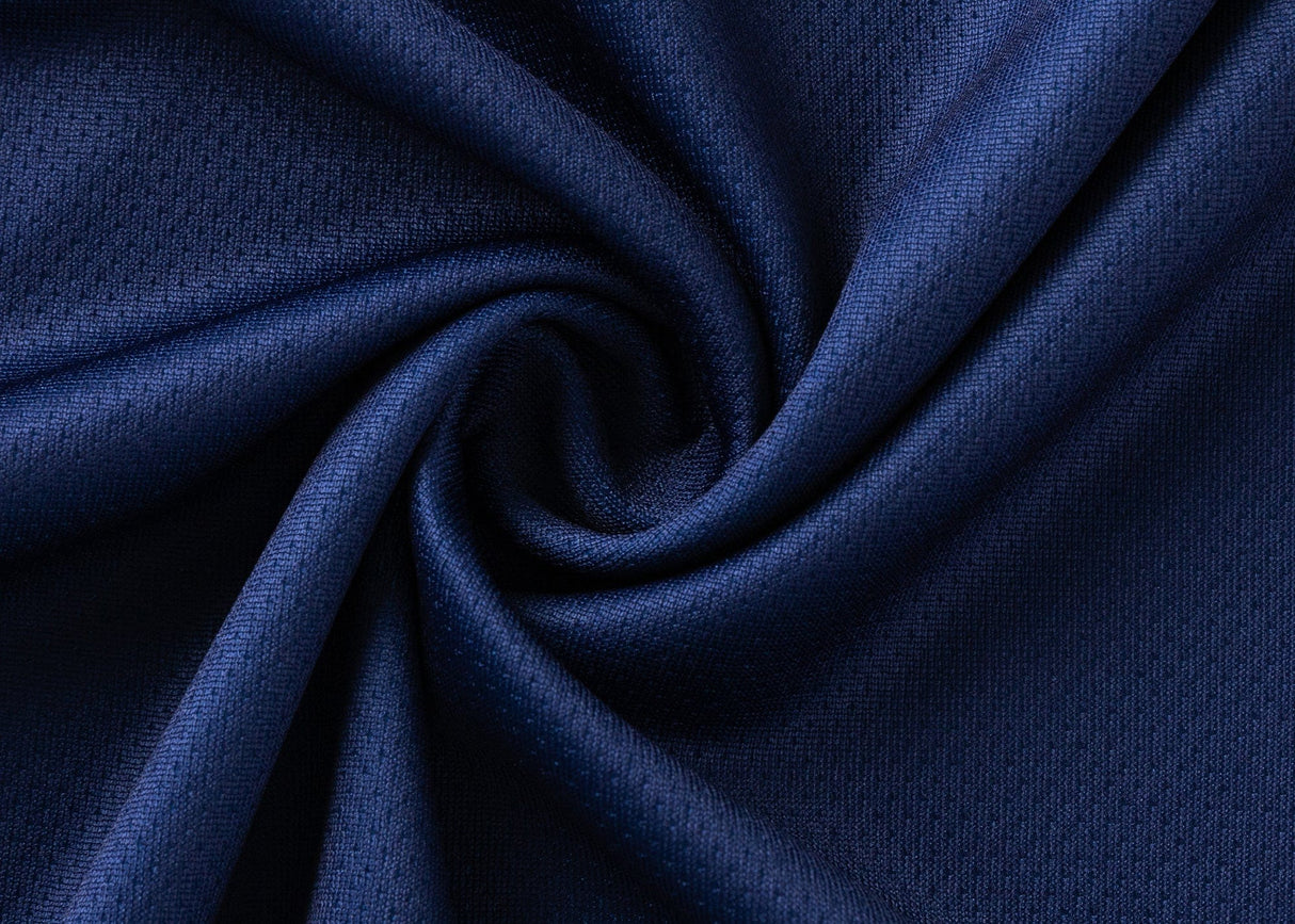 A close-up of the Blues Super Rugby 25/26 Team Polo by Classic Sportswear highlights its deep blue fabric, central spiral fold, and smooth texture.