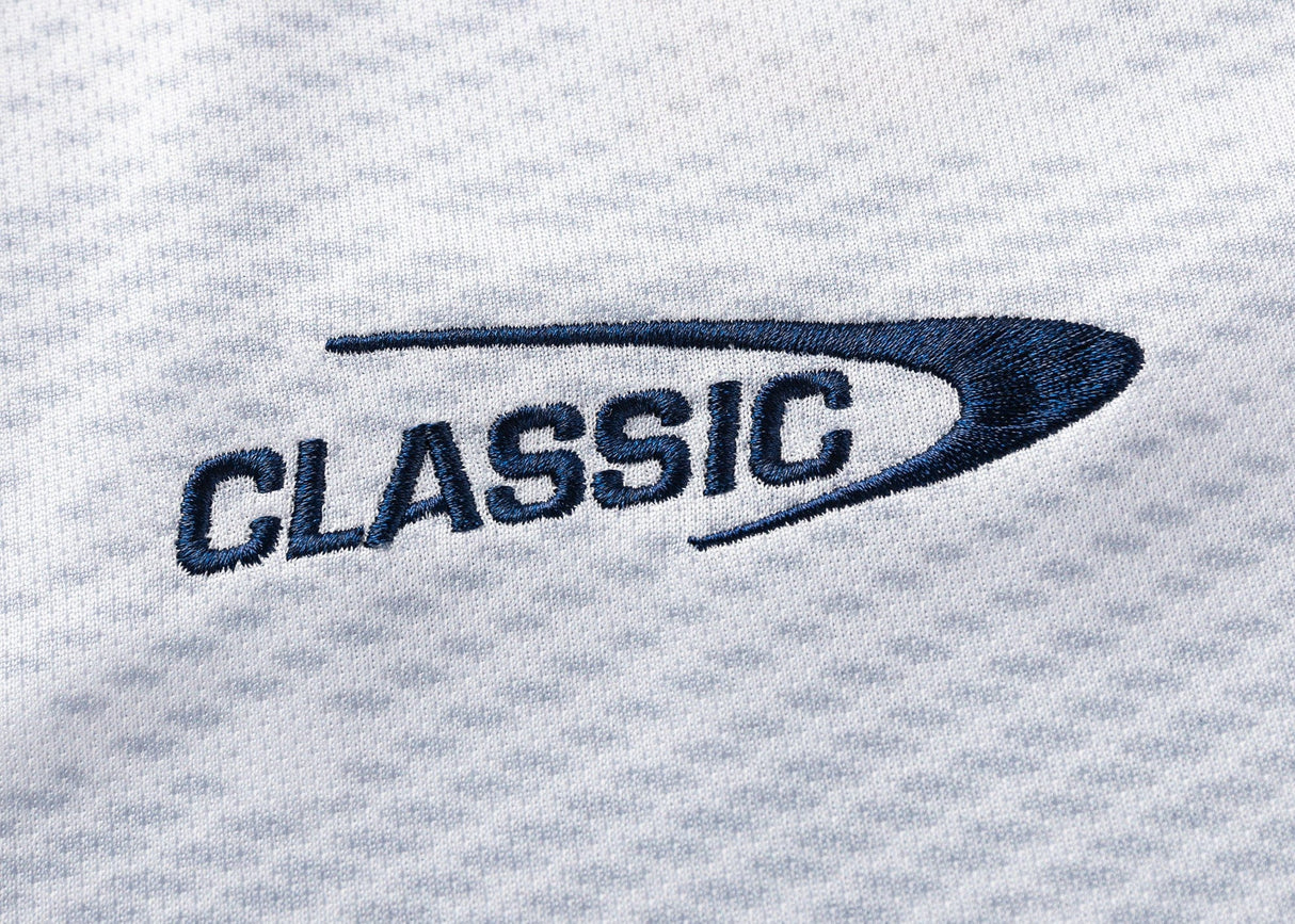 Embroidered "CLASSIC" in navy on textured white, inspired by the curved design of the Blues Super Rugby 25/26 Replica Away Jersey from Classic Sportswear.