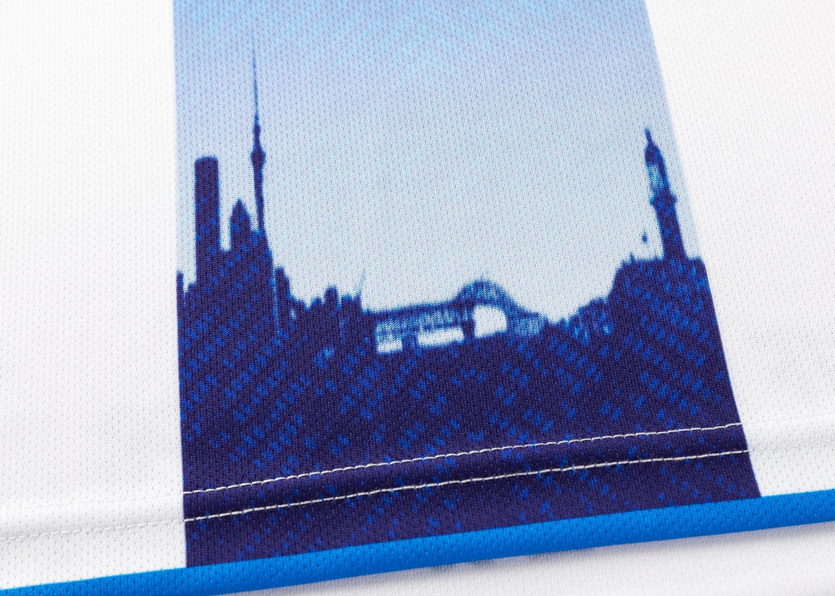 The Blues Super Rugby 25/26 Replica Away Jersey by Classic Sportswear features a city skyline in blue silhouette, embodying the dynamic spirit of the Blues team with its array of towers and buildings.