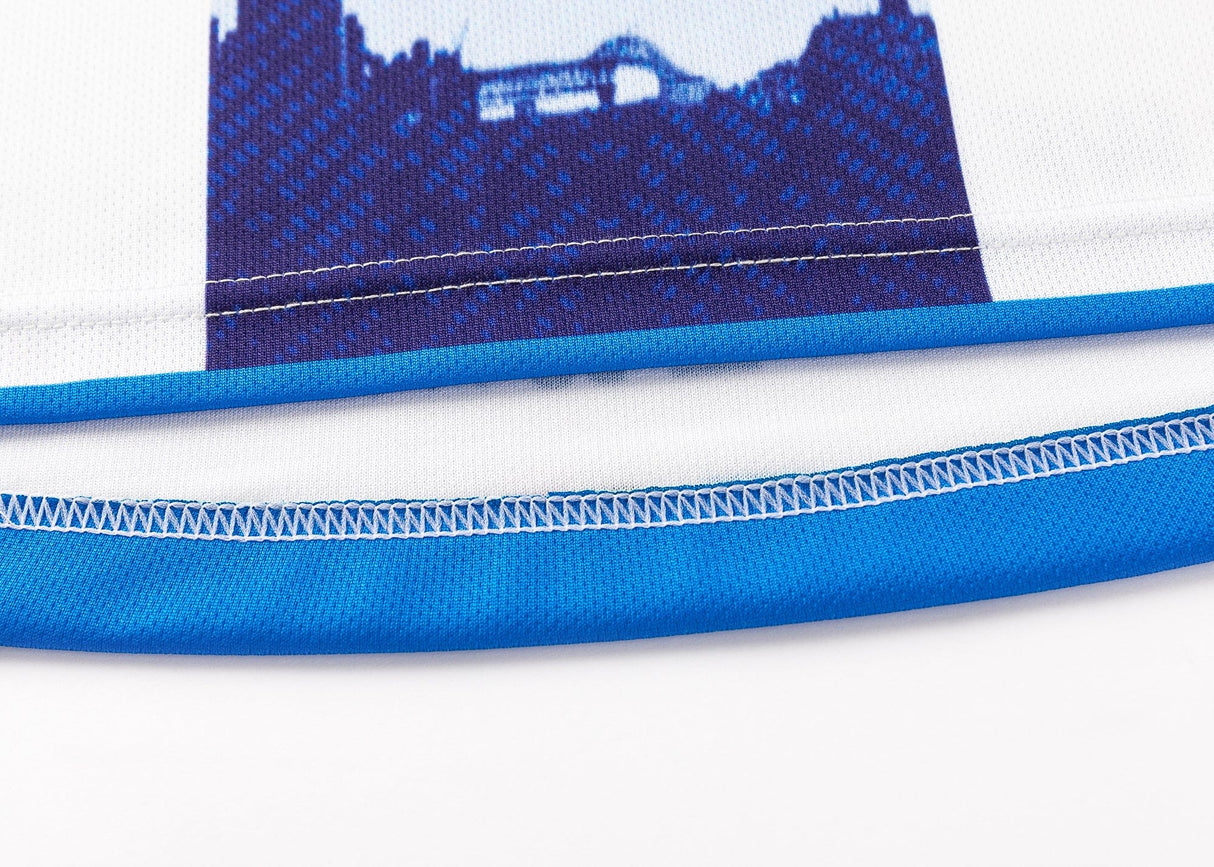 Close-up of a Classic Sportswear Blues Super Rugby 25/26 Replica Away Jersey, showcasing its blue and white design with graphic print and neatly sewn hem.