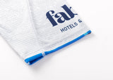 Close-up of white textured fabric with blue stitching resembling classic sportswear, featuring partial blue text "fab" and "HOTELS &", reminiscent of the sleek design from the Blues Super Rugby 25/26 Replica Away Jersey by Classic Sportswear.