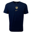 The Racing 92 Evergreen Tee 1 by Nike is a navy blue tee designed from premium cotton jersey, adorned with a small golden shield emblem and a gold Nike swoosh logo on the chest.