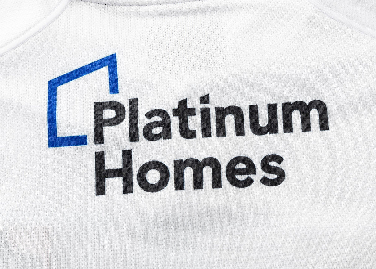 White fabric features "Platinum Homes" and a blue angular line logo in black, similar to the design on the Gallagher Chiefs Super Rugby Replica Away Jersey 25/26 by Classic Sportswear, capturing the essence of Super Rugby.