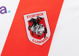 Close-up of the Dragons NRL 25/26 Replica Home Jersey logo by Classic Sportswear, showing a knight on a horse, embroidered on a white and red background.