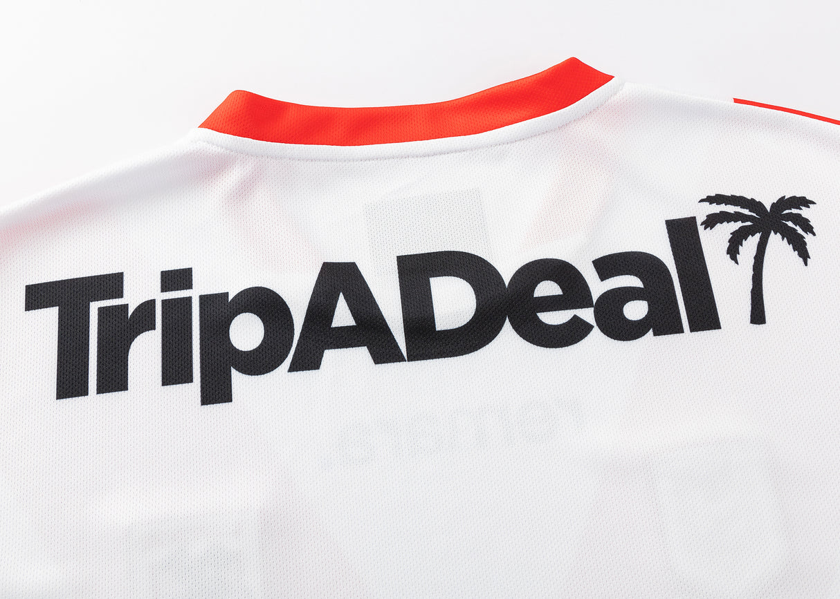 The Dragons NRL 25/26 Replica Home Jersey by Classic Sportswear features "TripADeal" in bold black text with a palm tree graphic on the back. Ideal for Dragons fans wanting to show team spirit.