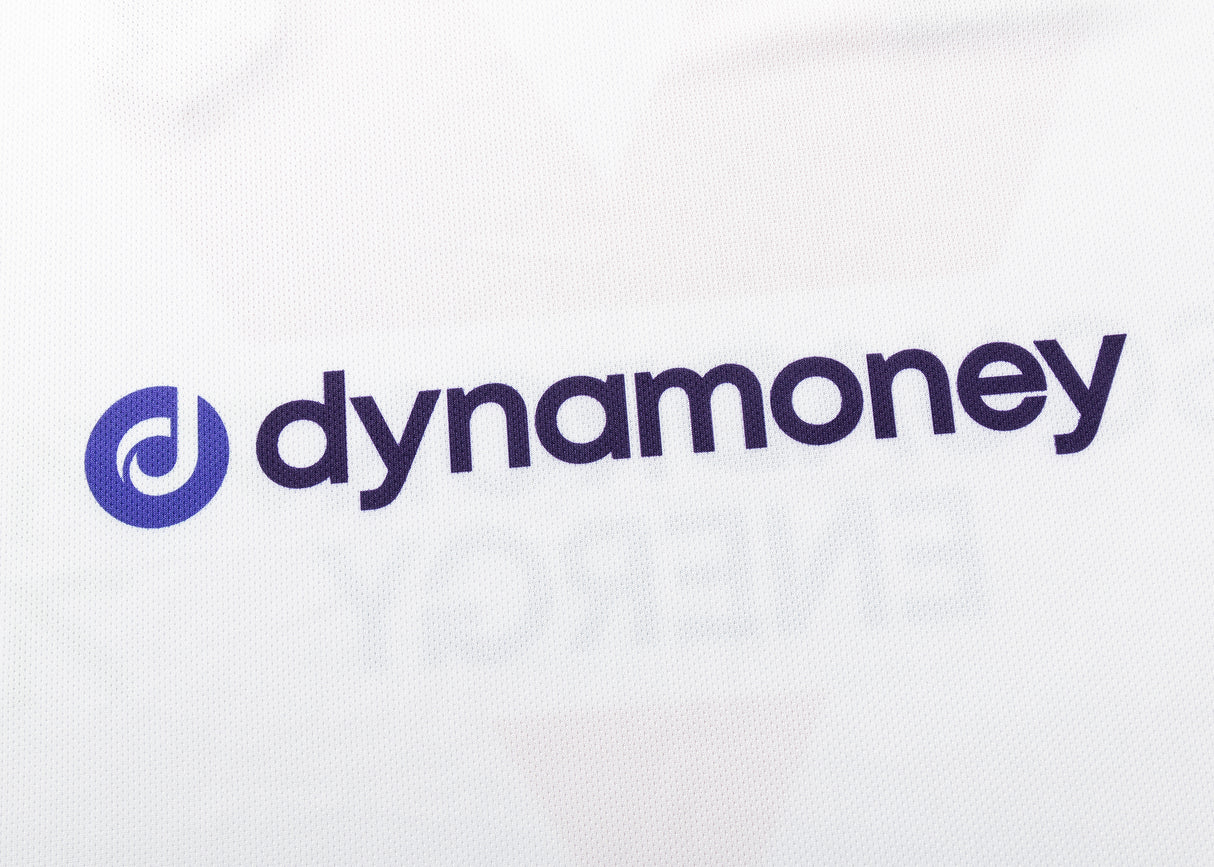 The image displays "dynamoney" in blue lowercase on white, with a blue circular logo to the left, resembling the distinct style of Classic Sportswear's Dragons NRL 25/26 Replica Home Jersey.