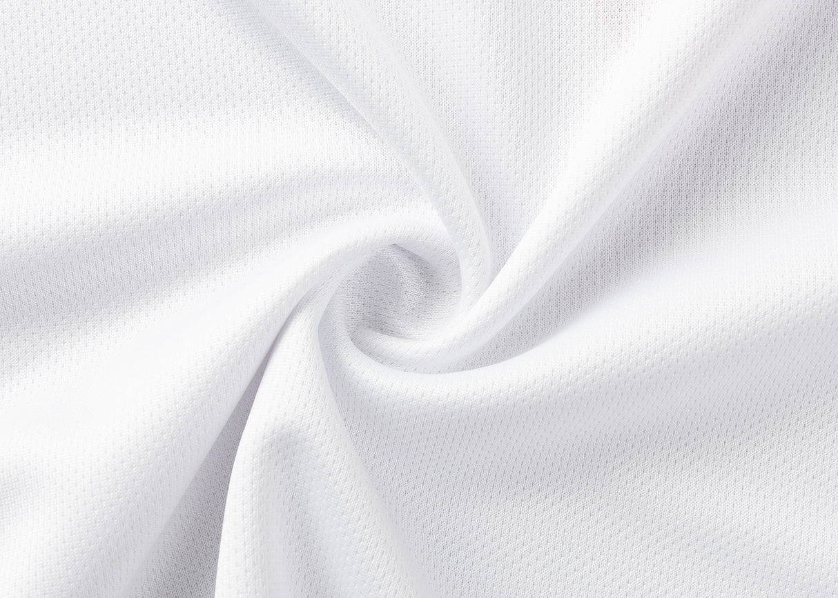 Close-up of Dragons NRL 25/26 Replica Home Jersey by Classic Sportswear, white fabric with a textured, perforated pattern reminiscent of classic sportswear, arranged in a spiral fold.