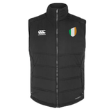 The Ireland Shield Core Gilet by EMB Canterbury is a black sleeveless padded gilet with a zipper front, featuring a white logo on the left chest and an Ireland Shield emblem with green, white, and orange stripes on the right chest.