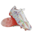 A pair of IDA Sports Helia Elite Limited Edition Pride FG women's soccer cleats in white, with multicolored geometric patterns, "IDA" branding on the side, and pink-tinted translucent firm ground soles.