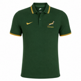 The Springboks 26/27 Pique Polo by Nike is a green polo with yellow trim, featuring the Springboks logo on the left chest and a Nike swoosh on the right—ideal for South African rugby fans.