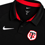 The Stade Toulousain Training Polo by Nike features a black design with a red-lined collar, white Nike logo on the chest, and a red and white shield emblem with interlocking letters—a classic athletic shirt for any sport collection.
