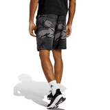 A person is seen from the back wearing All Blacks Camo Shorts by adidas, white socks, black and white athletic shoes, and a dark T-shirt.