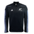 The Adidas All Blacks 24/25 Fleece 1/4 Zip top features a black design with a quarter zip and "All Blacks" logo, two white chest emblems, and light blue stripes on the sleeves. AEROREADY technology keeps you comfortable while showing your support.
