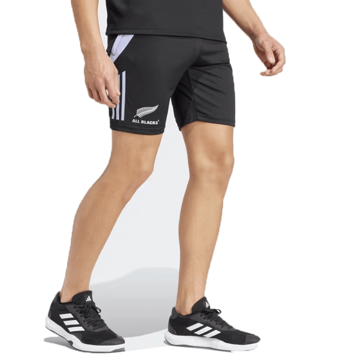 A person wearing the All Blacks 24/25 Performance Gym Shorts by adidas, adorned with blue stripes and made from recycled materials, paired with black socks, stands against a white background.