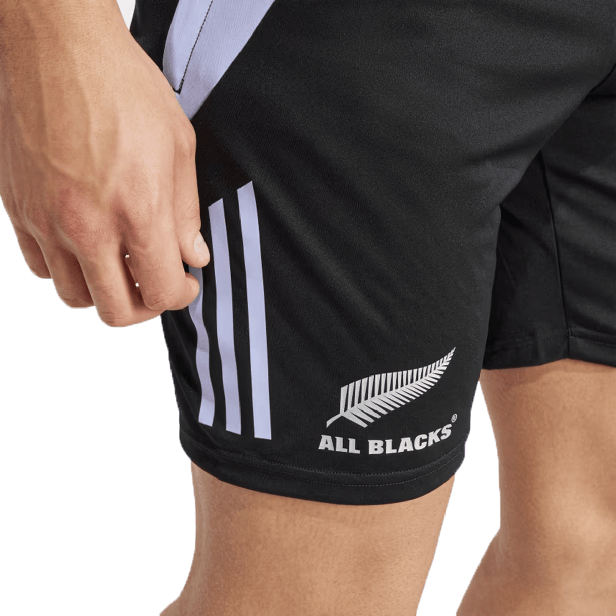 Close-up of a person wearing adidas All Blacks 24/25 Performance Gym Shorts, made from recycled materials and showcasing the logo with a silver fern design and white side stripes.