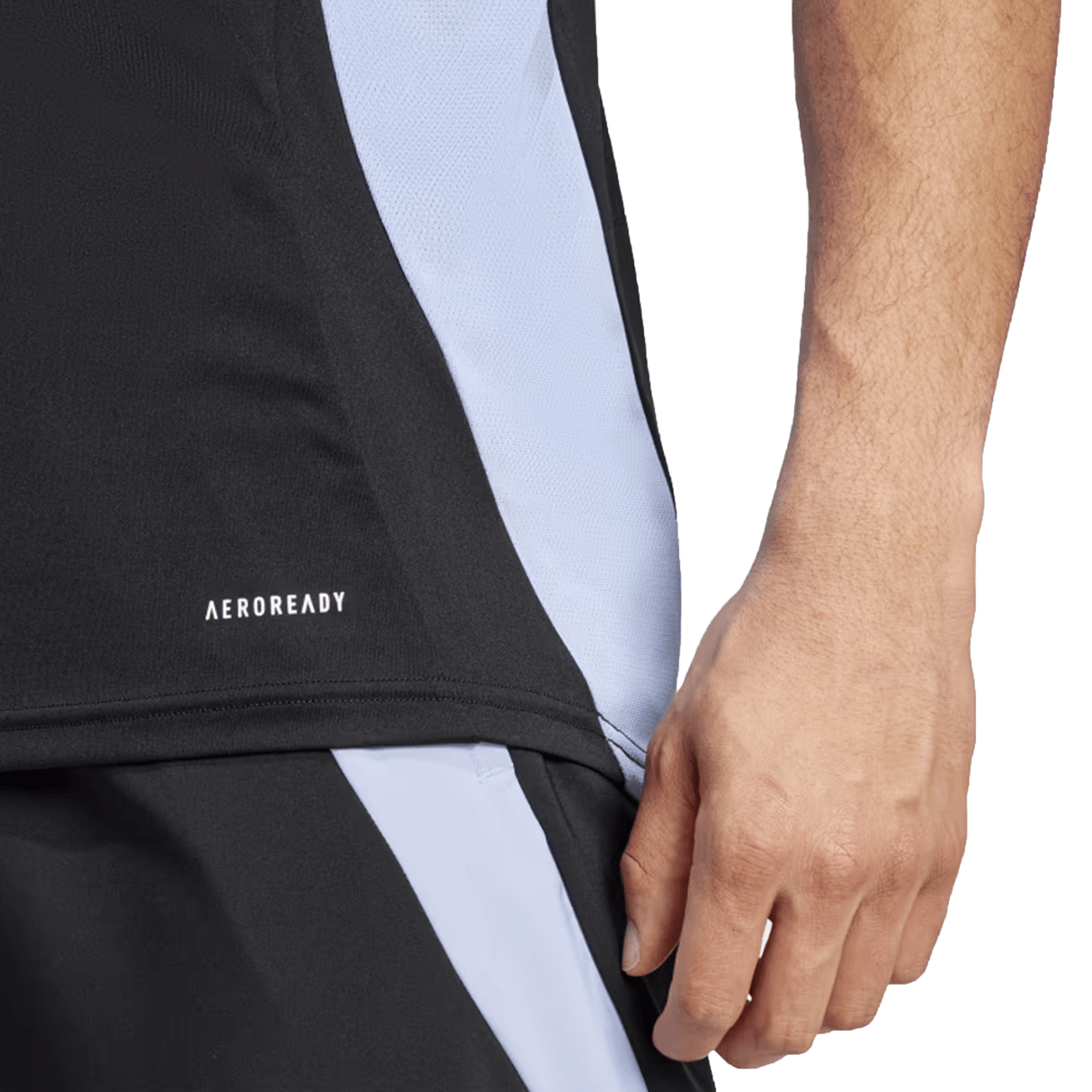 Close-up of a person wearing a black and white All Blacks 24/25 Performance Singlet by adidas, focusing on the side panel of the singlet and the hand.