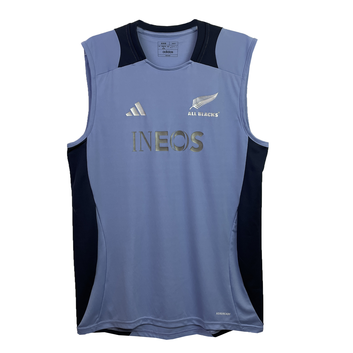 The All Blacks 24/25 Performance Training Singlet by adidas is sleeveless and gray with black shoulder and side panels, featuring adidas, INEOS logos, "All Blacks" text, and a silver fern emblem. It utilizes AEROREADY Technology for superior comfort in workouts.