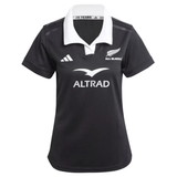 The Women's All Blacks 24/25 Home Supporters Jersey by adidas is a black rugby jersey with a white collar, silver fern logo, "ALL BLACKS" text, three stripes, and "ALTRAD" sponsor logo. It features AEROREADY technology for enhanced comfort and performance.