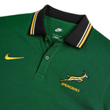 Green pique Springboks Heritage Pique Polo by Nike featuring a black collar with white and yellow stripes, an embroidered gold leaping antelope logo, and the text “SPRINGBOKS” on the chest.