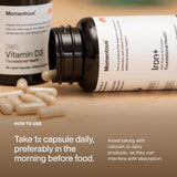A bottle of Momentous Iron+ from Momentous lies on a table with scattered capsules. Instructions recommend taking one capsule daily in the morning before food, as an iron supplement for energy support, avoiding calcium or dairy.