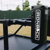 A close-up of the IronBack Gorilla 8 Man Scrum Machine outdoors, highlighting its padded arm and sturdy metal platform.