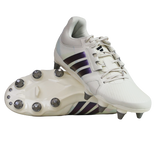 A pair of adidas Kakari Avaglide SG rugby boots in Off White/Grey Five, with one boot upright and the other displaying the metal-studded sole for soft ground play.