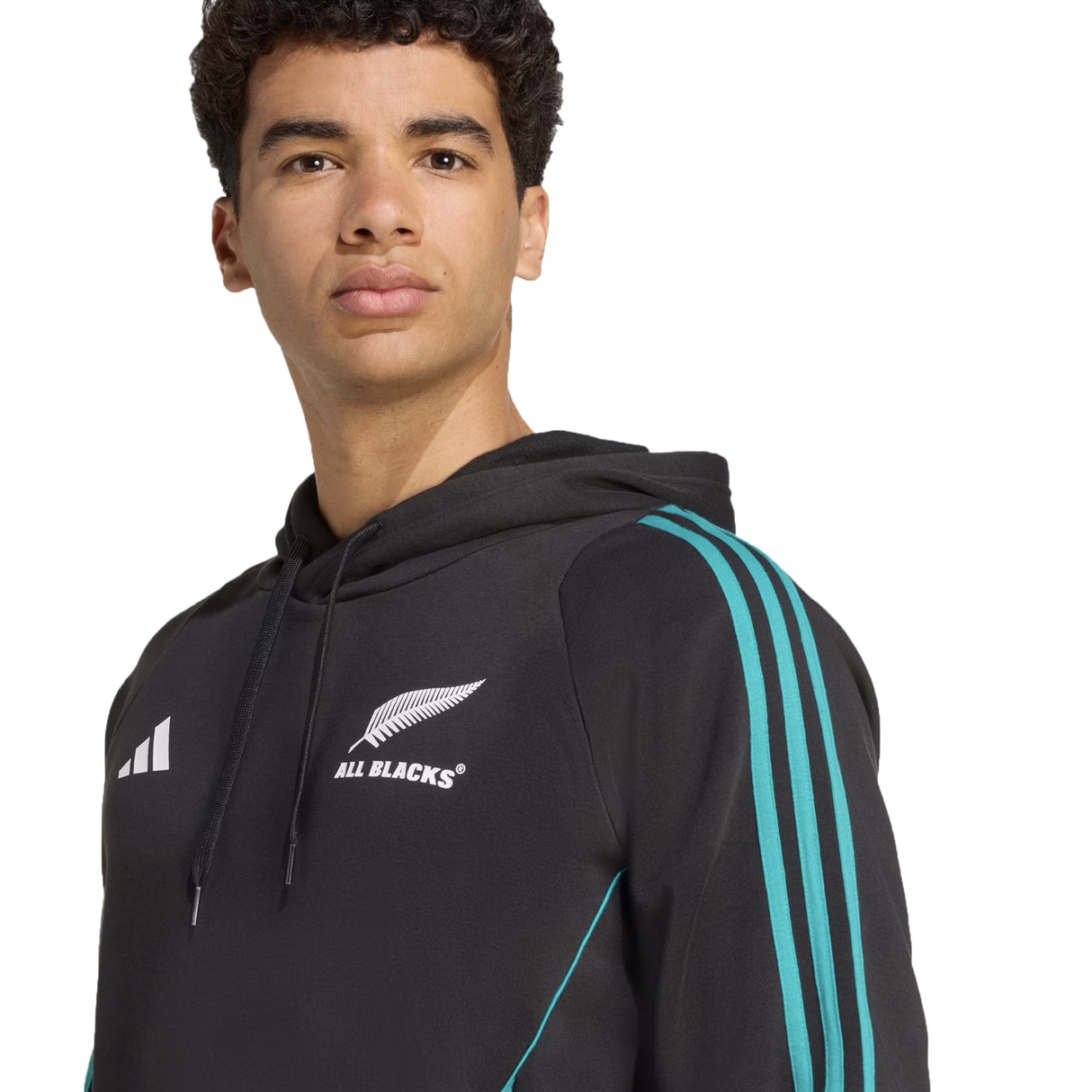 A young man wears the All Blacks 25/26 Training Hoodie by adidas, featuring teal stripes and the All Blacks rugby team logo on the chest.