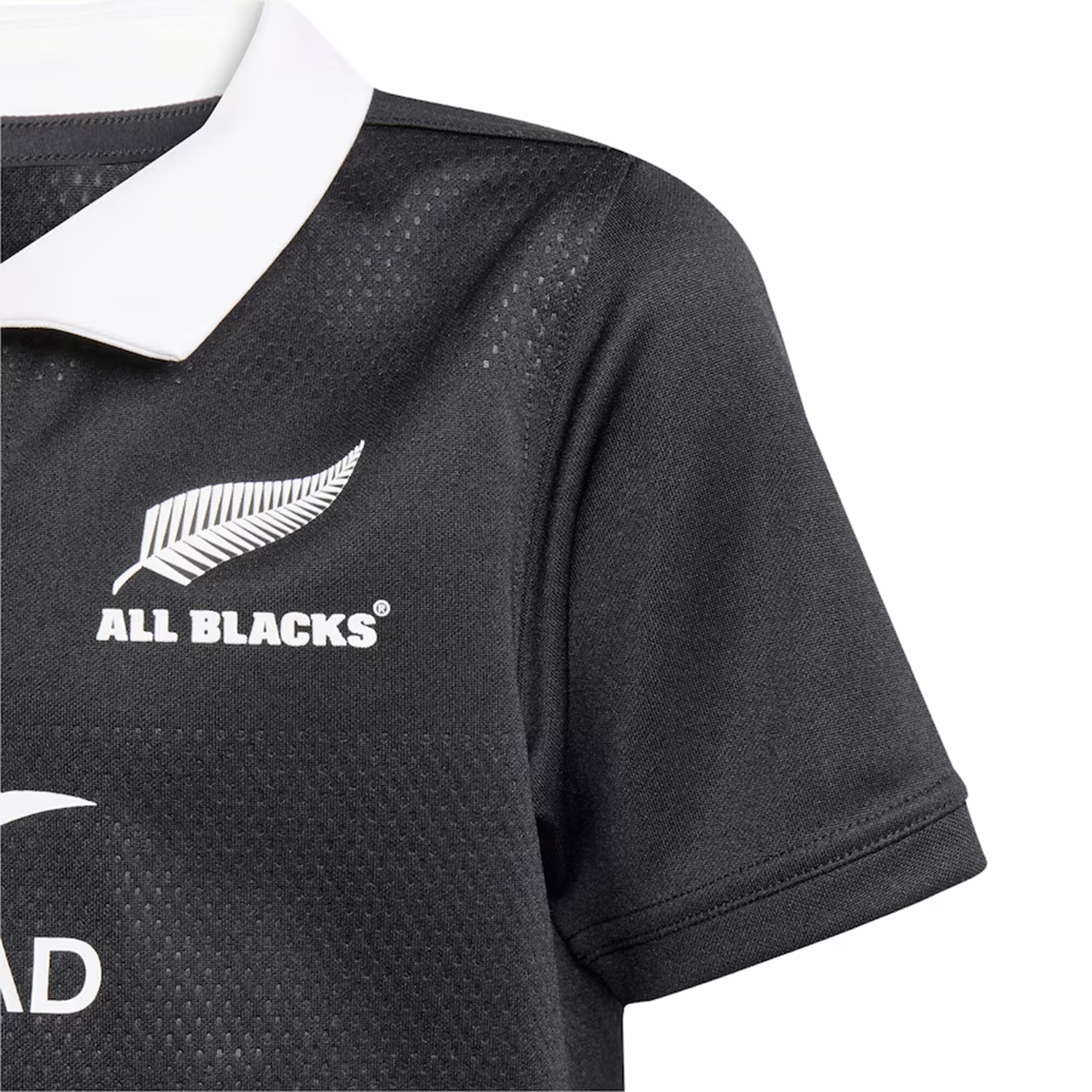 Close-up of the adidas Youth All Blacks 25/26 Replica Home Jersey in black with a white collar, silver fern, and All Blacks logo—a must-have replica jersey for young fans.