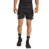 Person wearing adidas All Blacks 25/26 Replica Home Shorts, black socks, and black running shoes. Upper body partially visible. These shorts feature dual logos for an authentic rugby look.