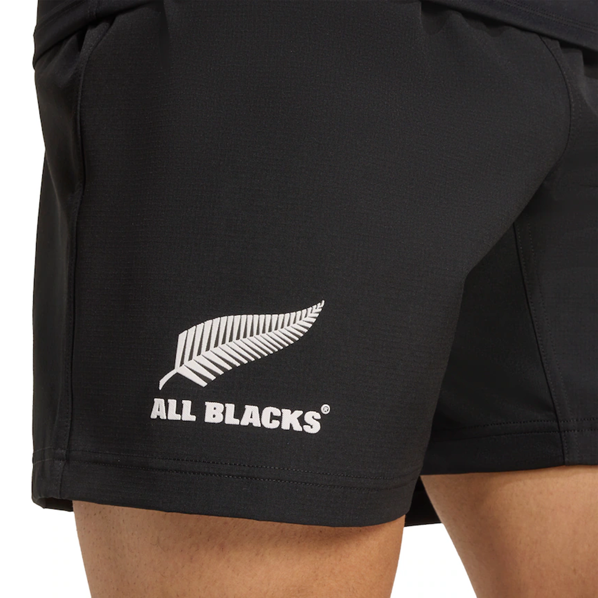 Close-up of adidas All Blacks 25/26 Replica Home Shorts—official replica shorts featuring the silver fern logo and "ALL BLACKS" text, proudly representing New Zealand’s national rugby team.