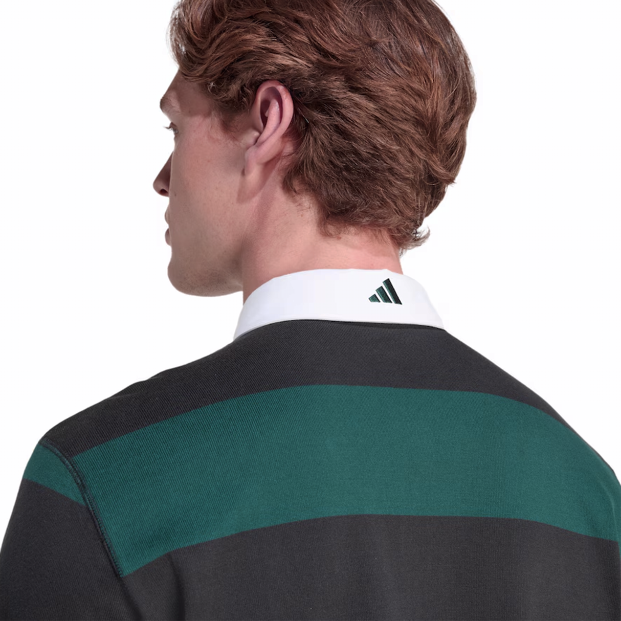 A person with brown hair is shown from behind, wearing the adidas All Blacks 25/26 Long Sleeve Heritage Polo with green and black stripes and an adidas logo on the back collar.