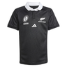 The Black Ferns WRWC25 Replica Home Jersey by adidas is a black short-sleeved rugby shirt with a white collar, chest logos including the Black Ferns and adidas emblems, plus two additional white emblems.