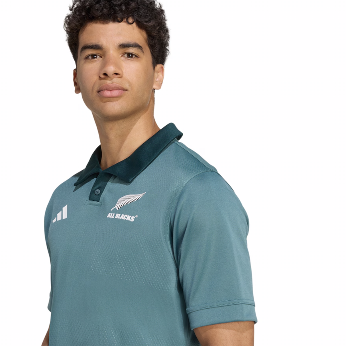 A person wearing the adidas All Blacks 25/26 Replica Training Jersey with a dark collar stands facing the camera against a plain white background.