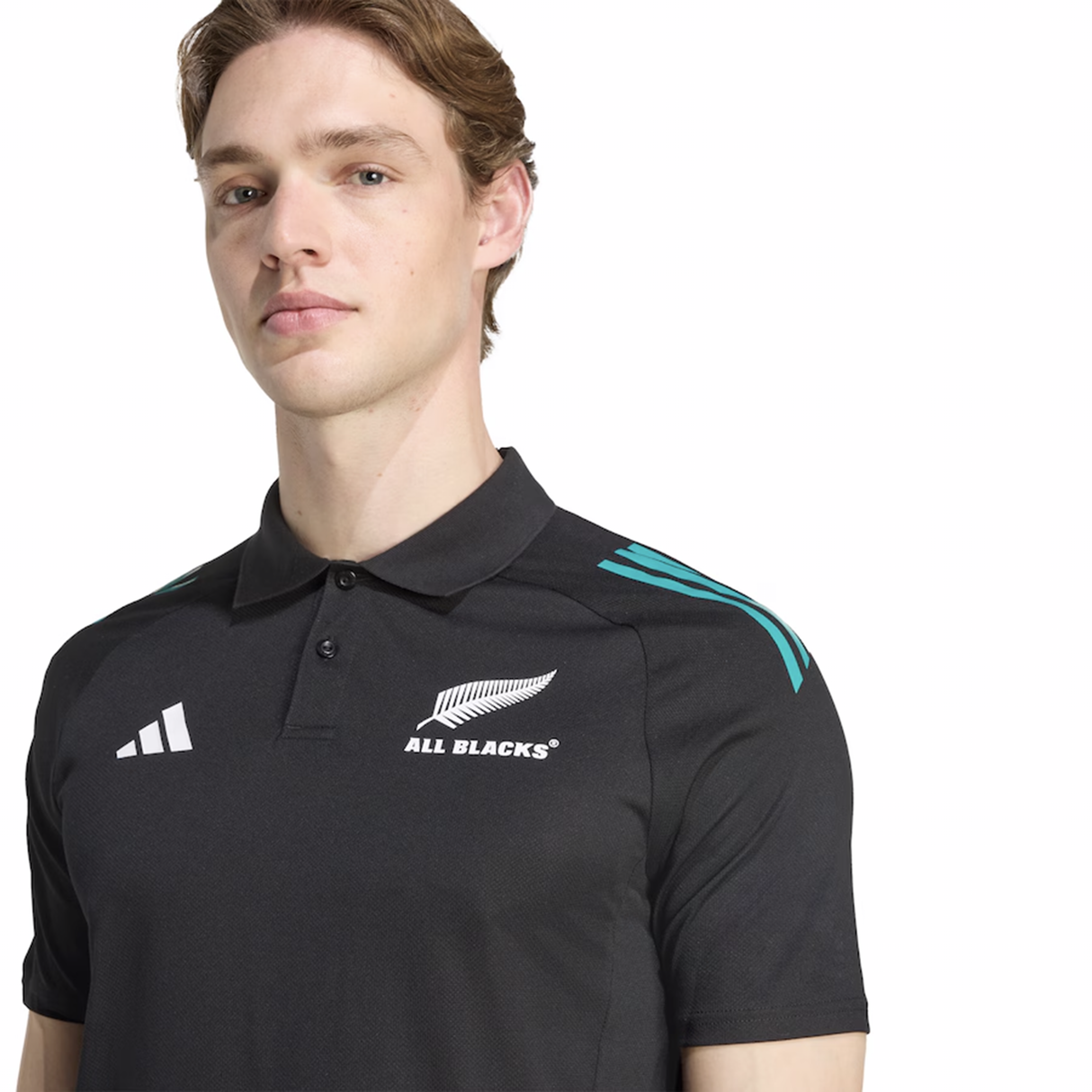 A person wears the All Blacks 25/26 Training Polo by adidas, a black shirt with teal shoulder stripes and team/adidas logos—a classic adidas training piece for rugby fans.