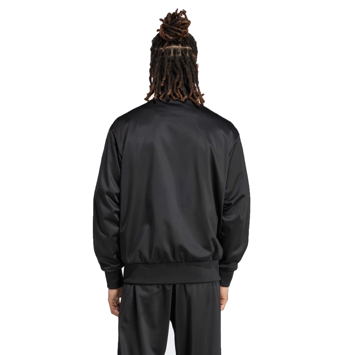 A person with dreadlocks is seen from behind on a white background, wearing the sleek black Originals Limited Edition All Blacks Firebird Track Top made of recycled polyester by adidas, featuring the iconic logo.