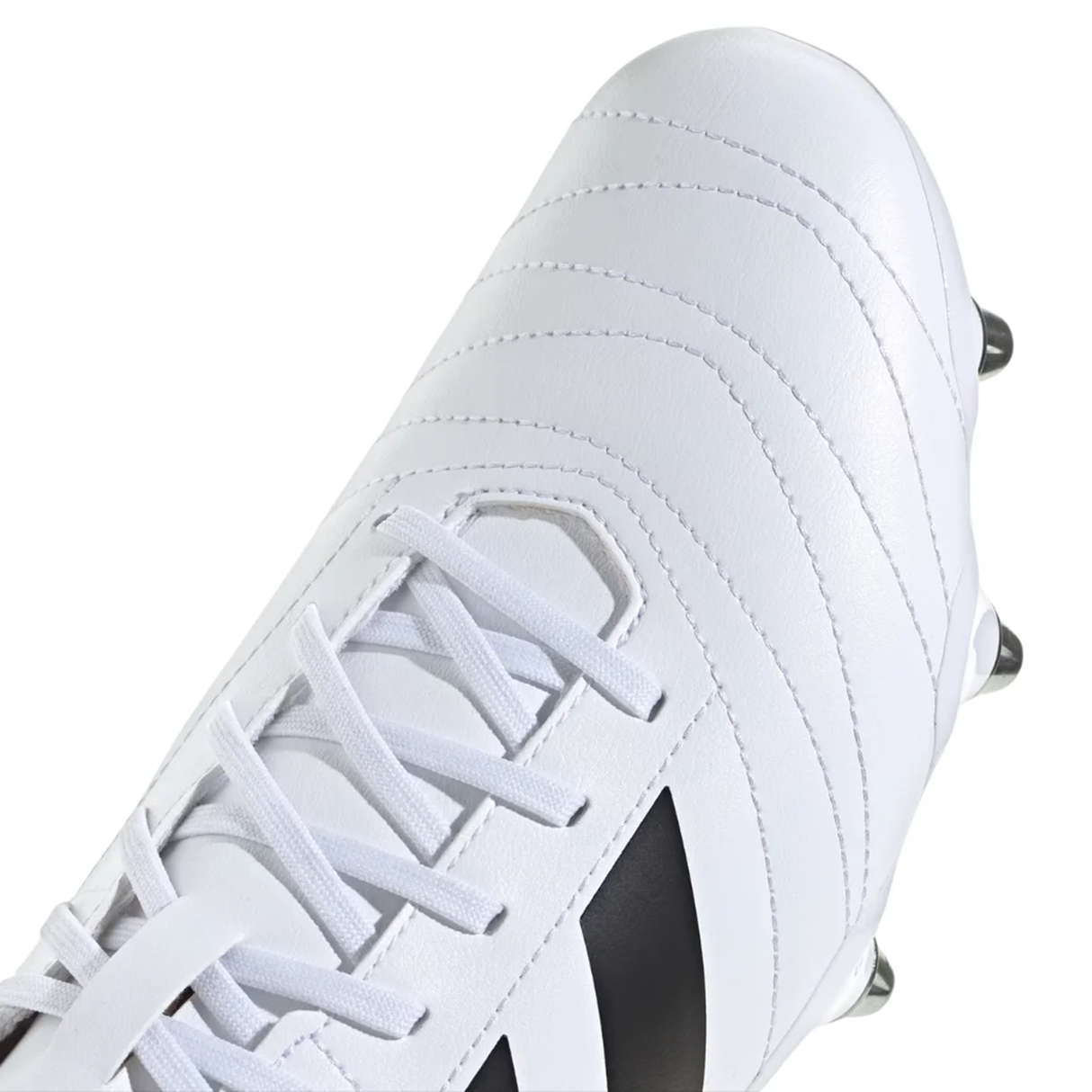 Close-up of the adidas Kakari SG rugby boot in White/Core Black/Silver Metallic, featuring white laces, visible stitching, and a partial black stripe on the side, all emphasizing its soft ground design.