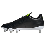 The adidas Kakari SG rugby boot in Core Black/Lucid Lemon/White features a black leather upper, white sole, six metal soft ground studs, and yellow logo accents, displayed side-on against a plain background.