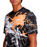 A person wears the adidas All Blacks 26/27 Captains Run Replica Jersey, featuring black and orange colors, comic-style illustrations, and the All Blacks logo on the chest.