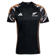 The All Blacks 26/27 Marvel Performance Training Tee by adidas features white logos, orange side accents, and patterned black, white, and orange sleeves—ideal as a rugby performance shirt.