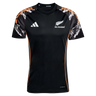 The All Blacks 26/27 Marvel Performance Training Tee by adidas features white logos, orange side accents, and patterned black, white, and orange sleeves—ideal as a rugby performance shirt.