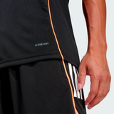 A person wears black athletic shorts and the adidas All Blacks 26/27 Marvel Performance Training Tee; only the lower torso and right hand are visible.