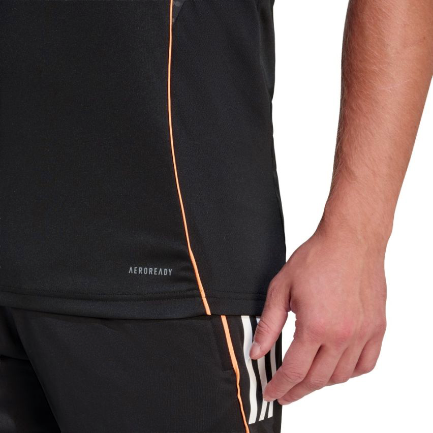 Close-up of a person wearing the adidas All Blacks 26/27 Marvel Performance Training Singlet in black, featuring "AEROREADY" text, paired with black adidas shorts with white stripes, highlighting the lower torso and right hand.