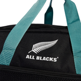 The adidas All Blacks 25/26 Duffle features teal handles, a black body, the iconic white silver fern, and "ALL BLACKS" text—ideal for rugby training or as your everyday adidas bag.