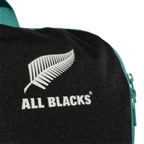 Close-up of the All Blacks 25/26 Backpack by adidas, showing the white fern logo, "ALL BLACKS®" text, and a teal zipper on the right side.
