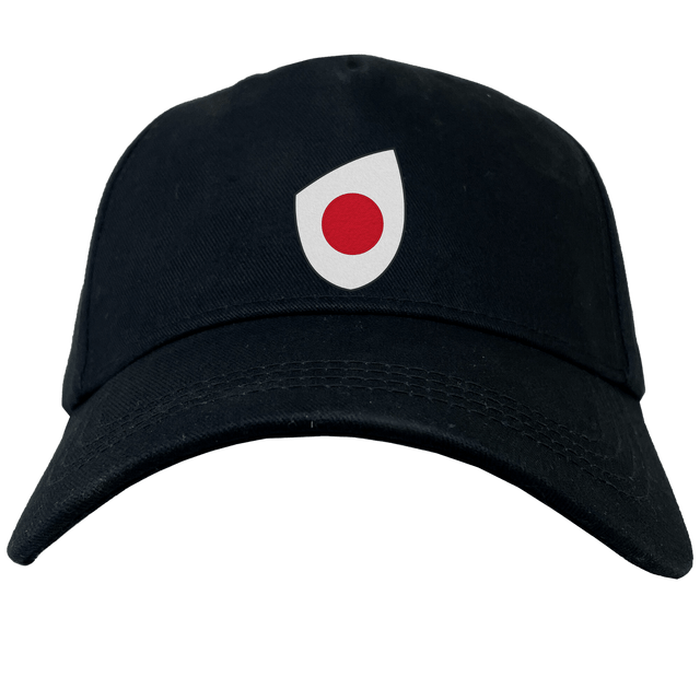 A sleek EMB Canterbury Japan Shield Flex Drill Cap in black, featuring a distinctive white and red emblem on the front.