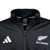 Close-up of a black adidas All Blacks 26/27 Marvel Track Top, featuring the adidas logo and All Blacks silver fern emblem on the chest, with a tag inside the collar—part of the exclusive Marvel Track Top collection.