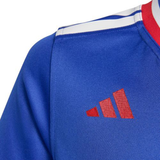 Close-up of the upper chest of the France FFR 25/26 Replica Home Jersey by adidas, featuring white shoulder stripes, a red collar, and a red adidas logo.